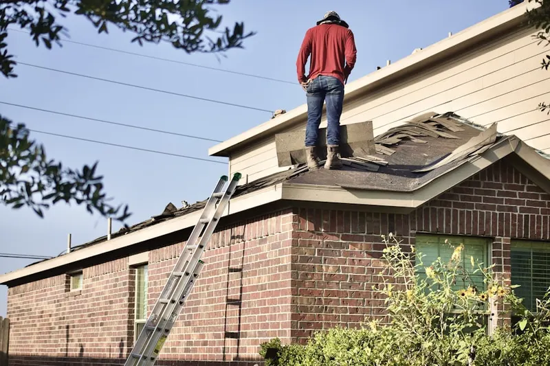 Professional roofer working on a residential roof in Fedhaven